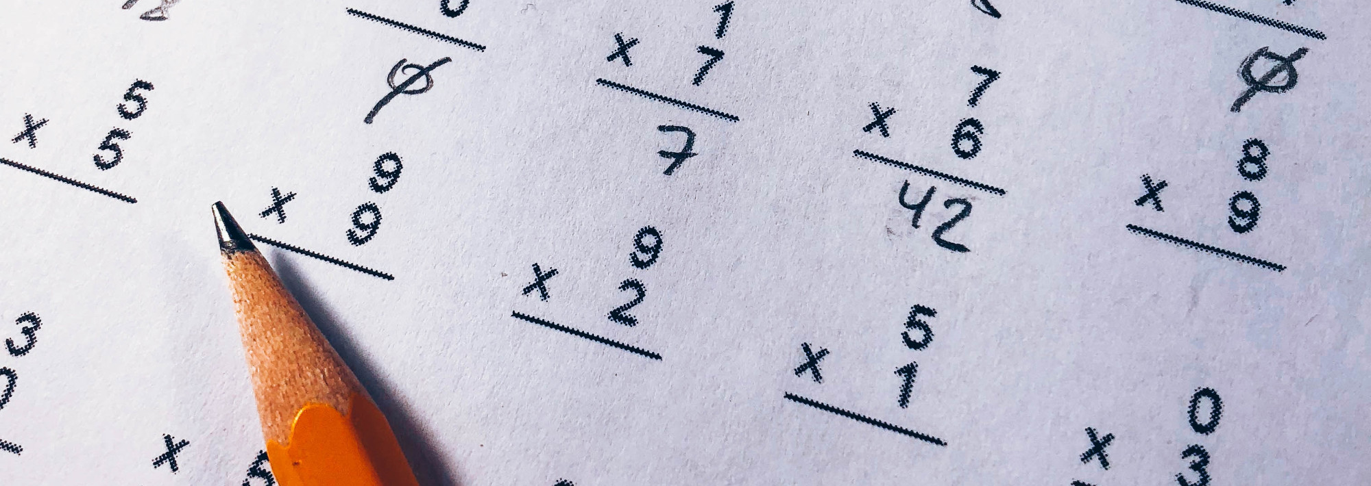 A piece of paper with single-digit multiplication problems and a pencil.