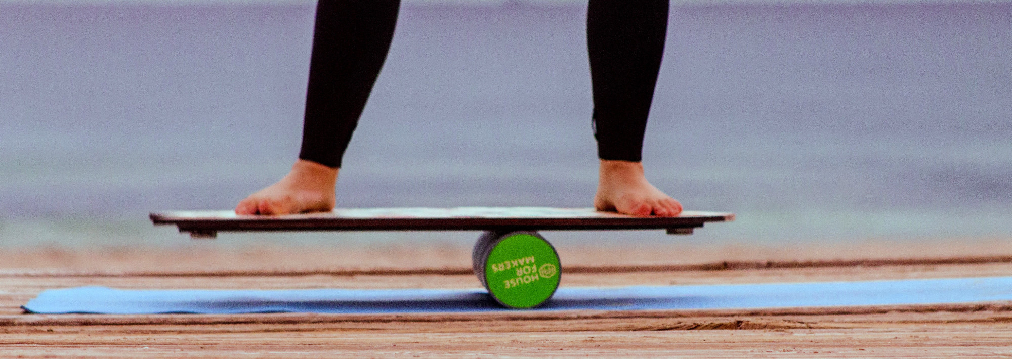 A person balancing on a balance board, as training before surfing.