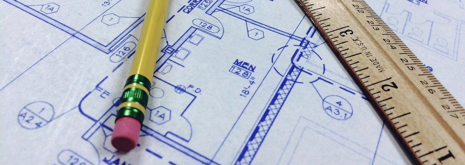 A blueprint, with a pencil and a ruler laid on top.