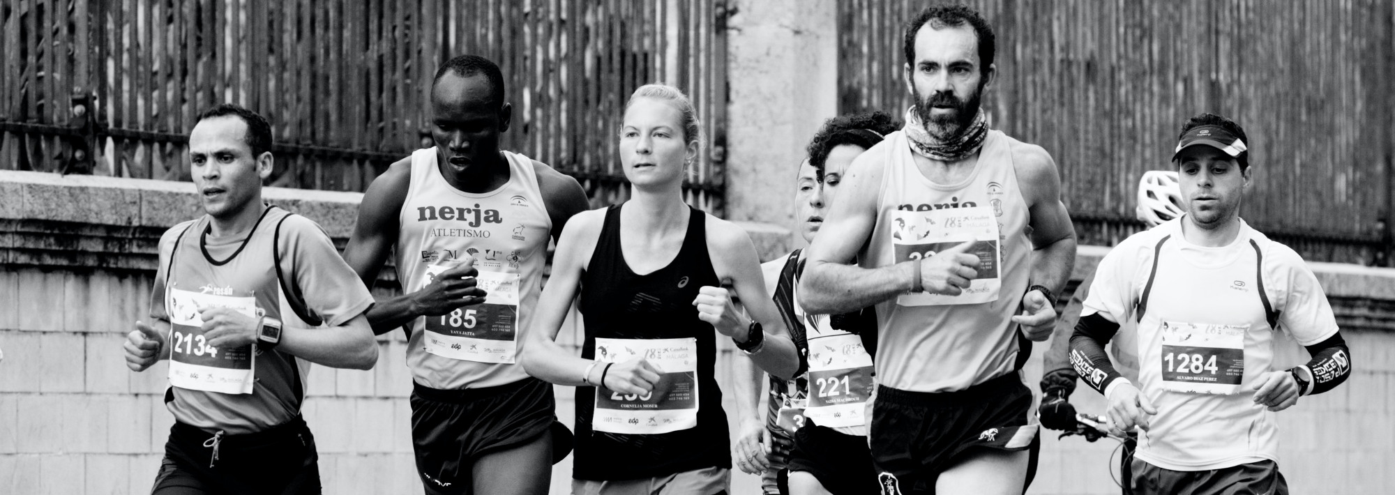 A group of people, of different races and genders, running.