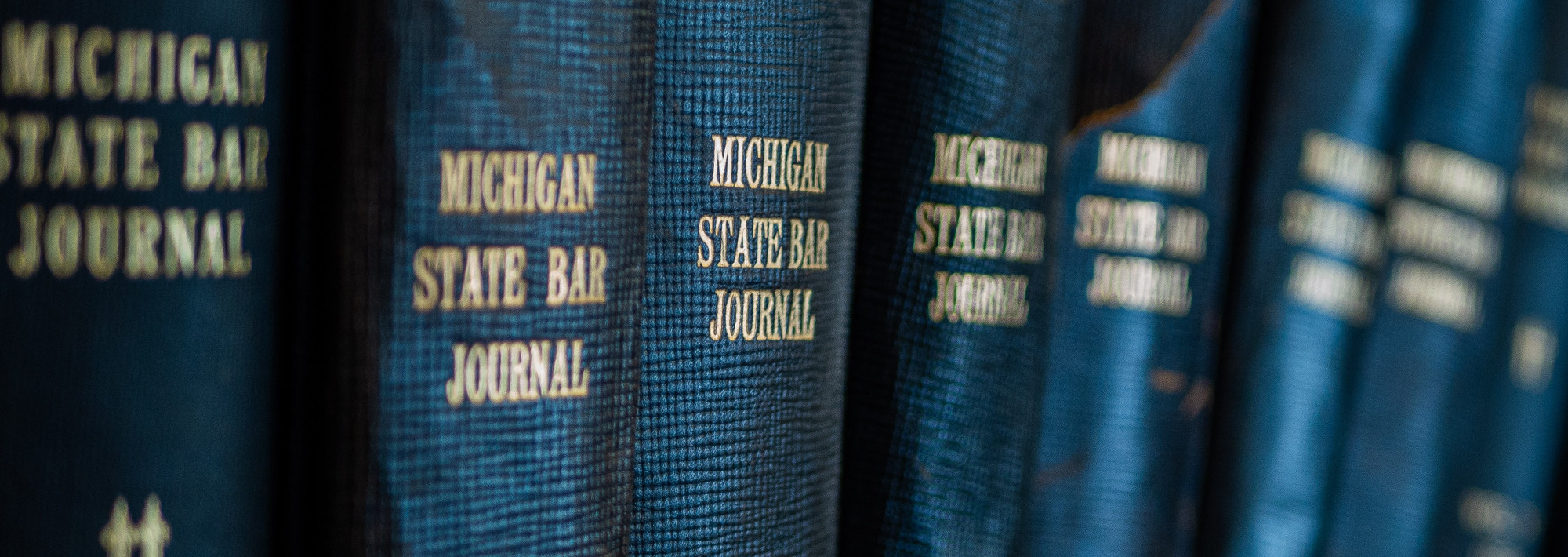 A row of books titled "Michigan State Bar Journal" (different volumes)