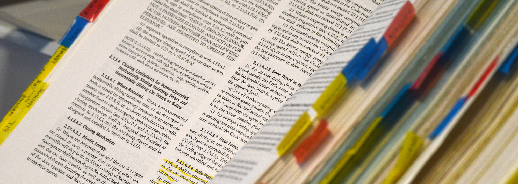 An open book with colored tabs on the pages to mark important pages.