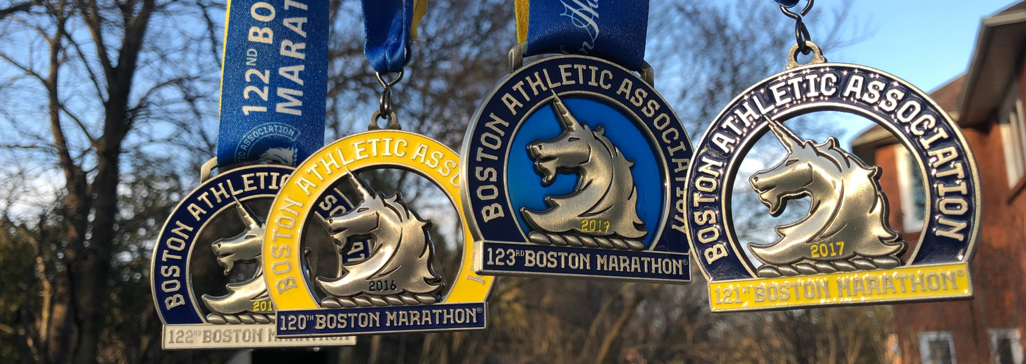 A row of blue and gold medals for the Boston Marathon