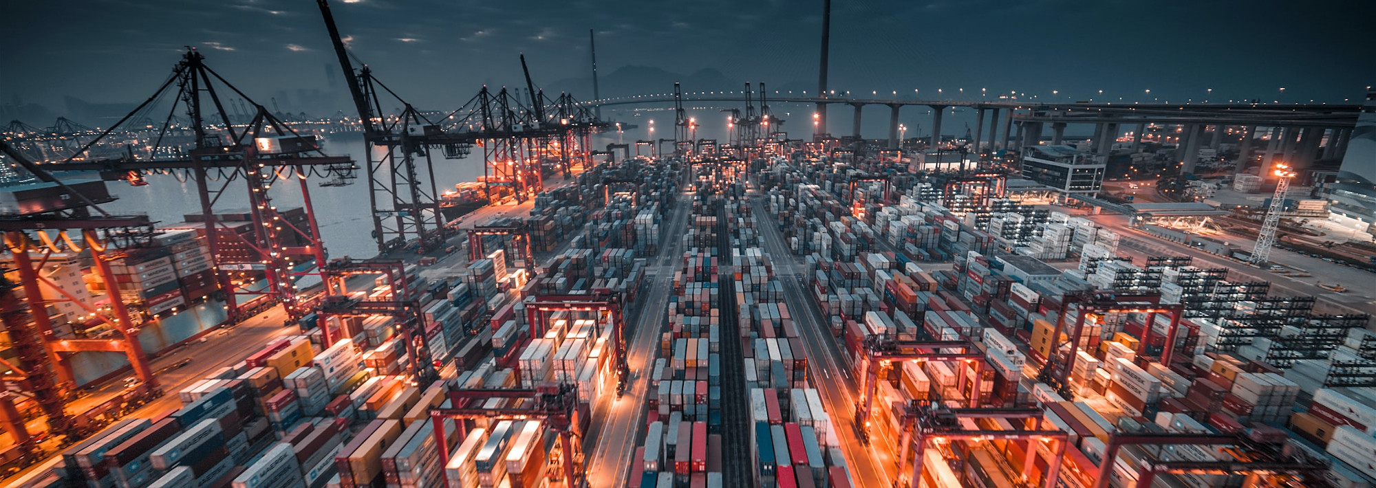 A busy container port at night, with hundreds, maybe thousands of containers